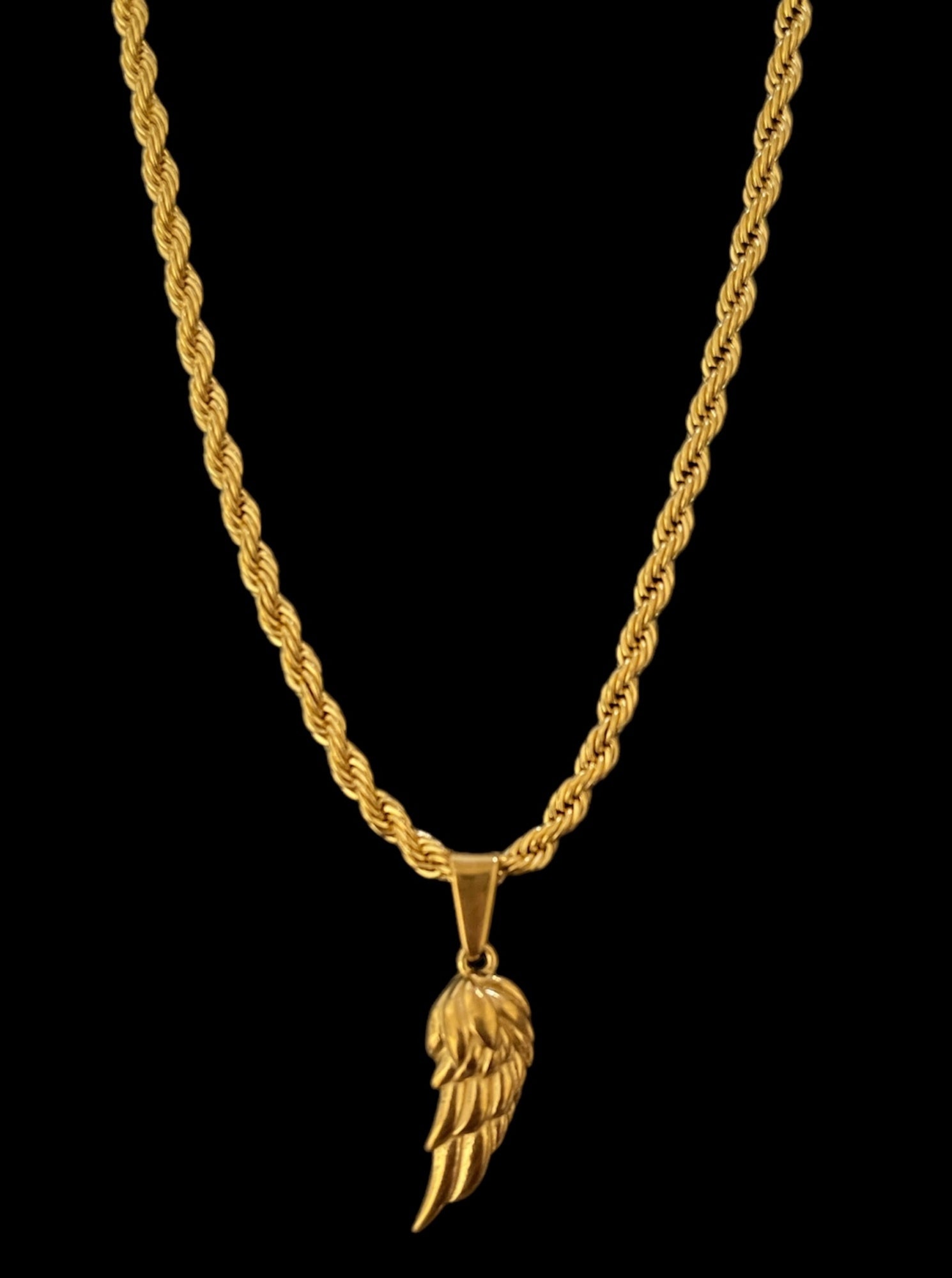 Elegant gold necklace with a wing-shaped pendant on a twisted chain, perfect for adding style to any outfit.