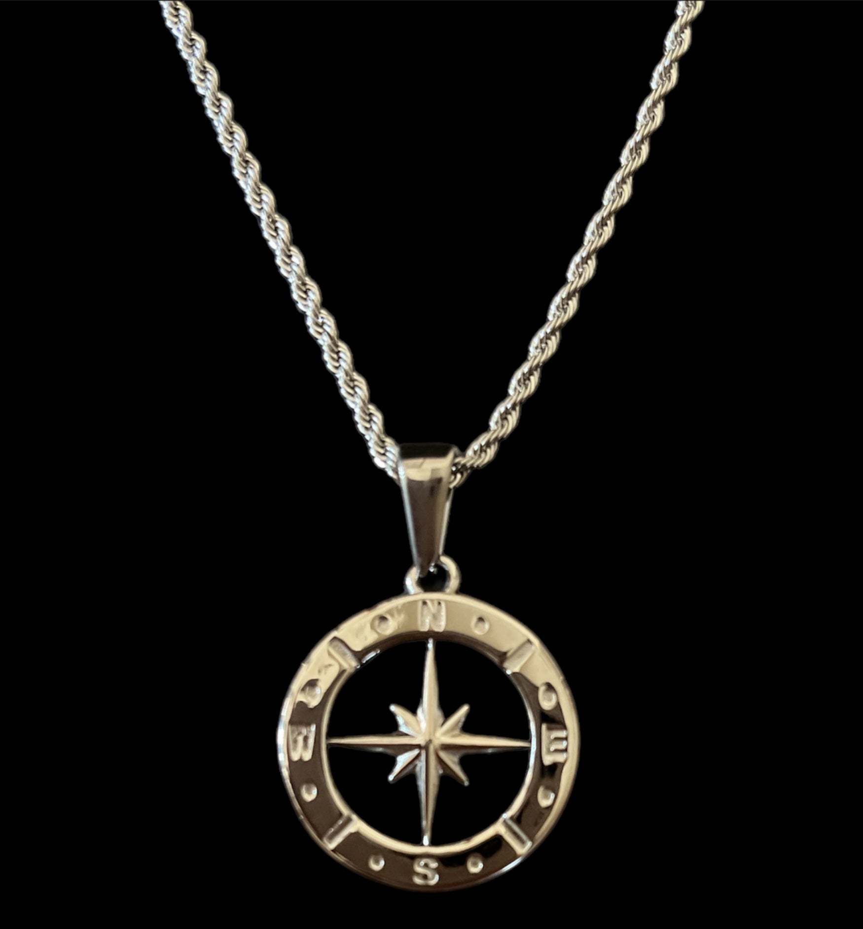Silver compass pendant necklace on twisted chain, symbolizing direction and adventure in stylish jewelry.